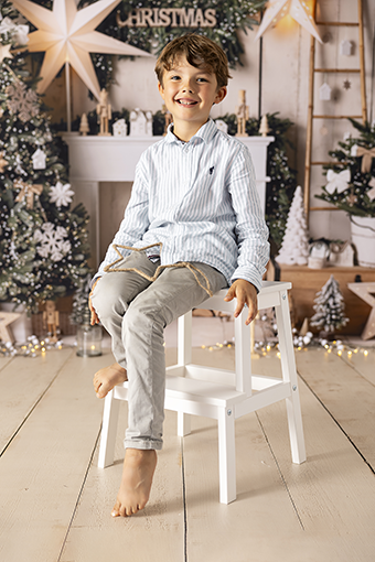 ¨Enfant qui pose dans un décor chic et lumineux pour une séance photo de Noël